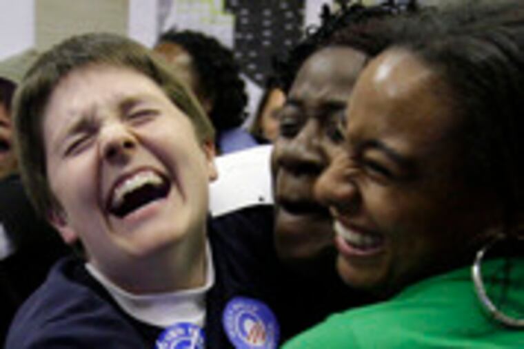 Supporters of Barack Obama react as they watch election returns on a big screen TV at an Obama campaign office last night.