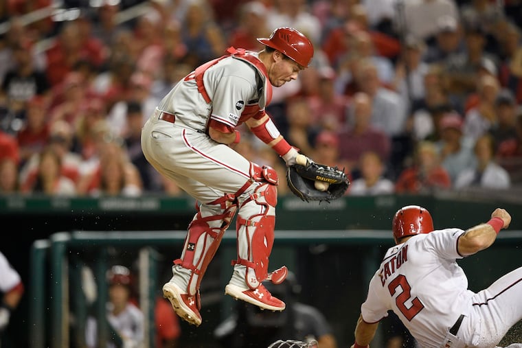 Phillies catcher Andrew Knapp, left, tries to apply a tag to Washington's Adam Eaton in the fifth inning Monday night.