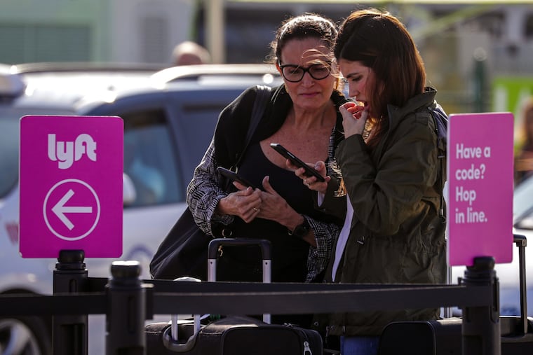 Denise Lyra (left) and her daughter Gabriela, arriving from Brazil, check her phone to figure out from where to get their ride at the pickup lot at Los Angeles International Airport in November 2019.