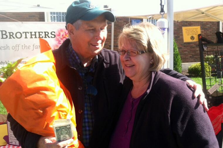 Regular customer Frank Kelly, of Deptford, comforts Mary Atkinson at Haddon Heights Farmers Market Sunday, Oct. 12, 2014. (Kevin Riordan/Staff)