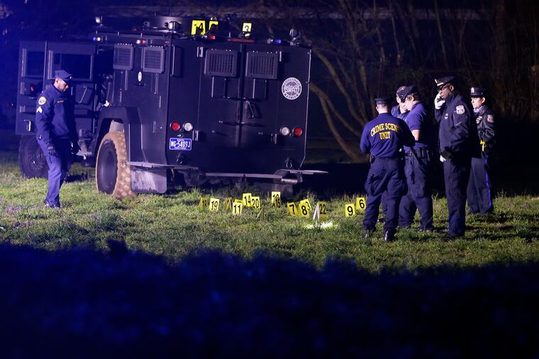 Crime Scene Unit officers mark shell casings near a SWAT armored car after a suspected gunman who held police at bay in Holmesburg for two hours was found critically wounded following a shootout with police.