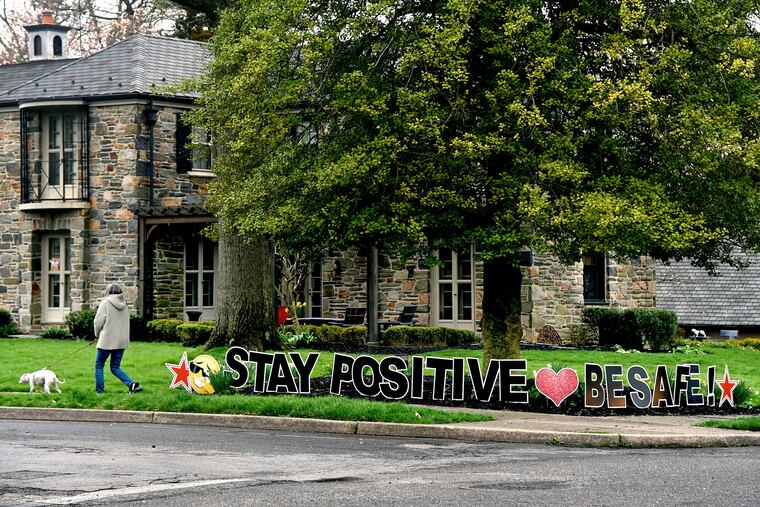 A home in Haddonfield displays a "positive" yard sign on Tuesday, on a day that New Jersey reports its highest single-day death toll from the coronavirus.