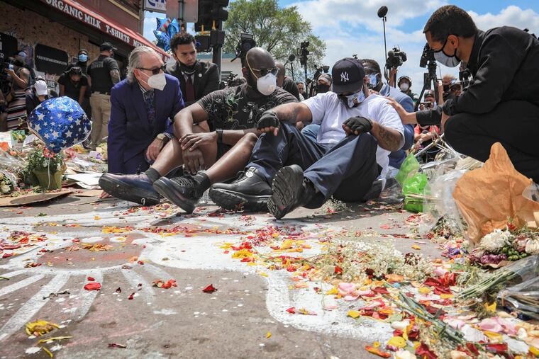 n this June 1 photo, an emotional Terrence Floyd, second from right, is comforted as he sits at the spot at the intersection of 38th Street and Chicago Avenue, Minneapolis, Minn., where his brother George Floyd, encountered police and died while in their custody.