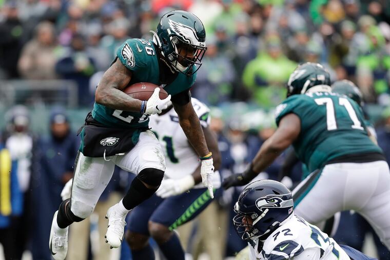 Eagles running back Mile Sanders leaps past Seattle Seahawks defensive tackle Al Woods in last week's loss.