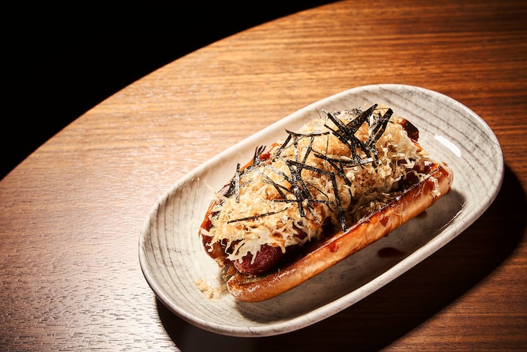 The wagyu hot dog at Almanac in Old City, topped with tonkatsu Sauce, Japanese slaw, bonito flakes, and nori.