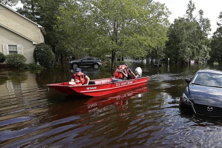 Members of the U.S. Coast Guard Shallow Water Rescue Team check on a flooded neighborhood in Lumberton, N.C., Monday, Sept. 17, 2018, in the aftermath of Hurricane Florence. (AP Photo/Gerry Broome)