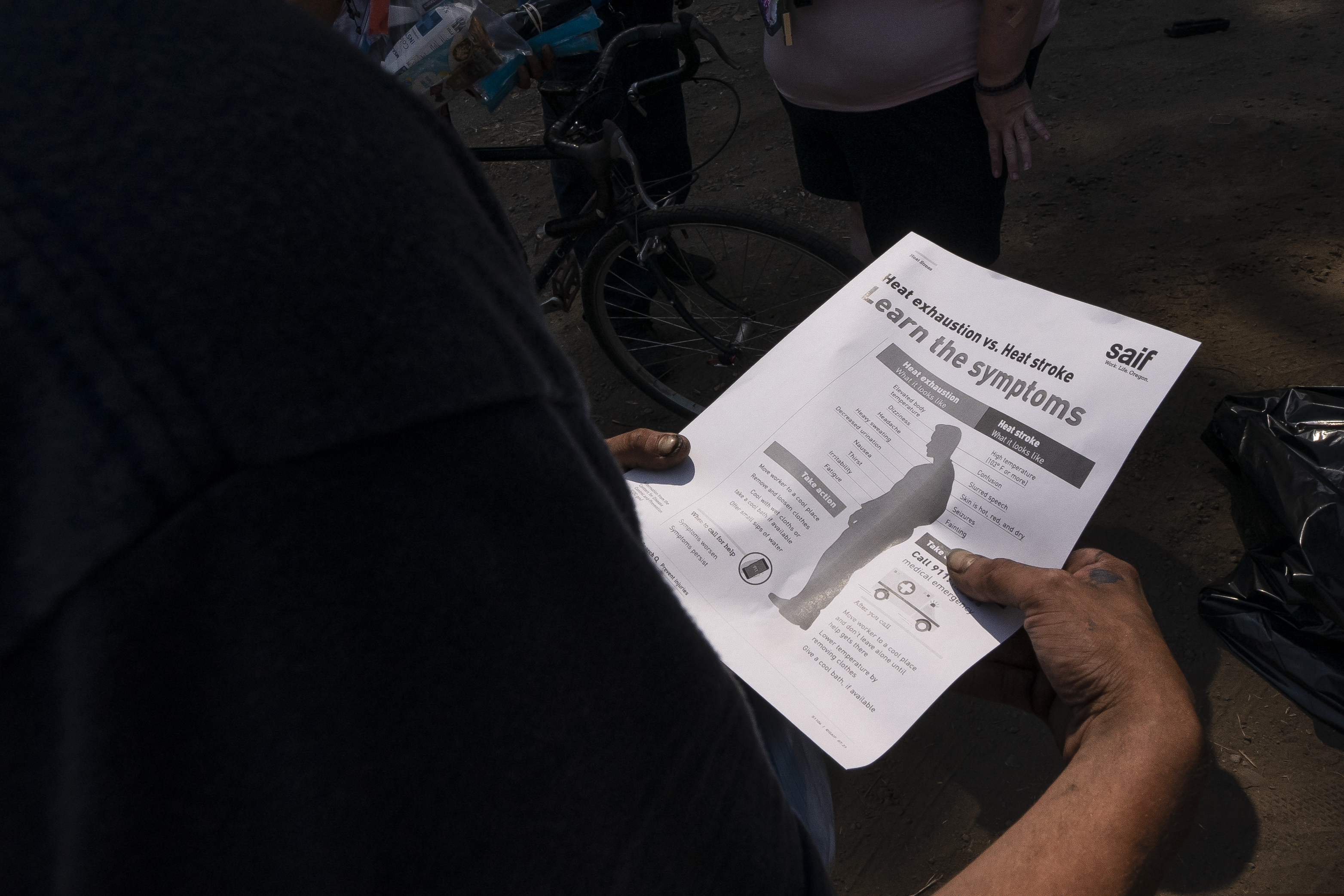A man reads an informational handout about heat stroke.