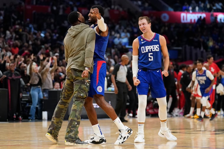 Paul George (center) celebrates with teammate John Wall during a Clippers game in 2022.