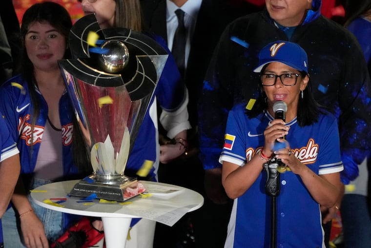 Venezuela's acting President Delcy Rodriguez, right, speaks next to the World Baseball Classic trophy a day after her team's victory over the United States in the championship match, at Miraflores presidential palace in Caracas, Venezuela, Wednesday, March 18, 2026.