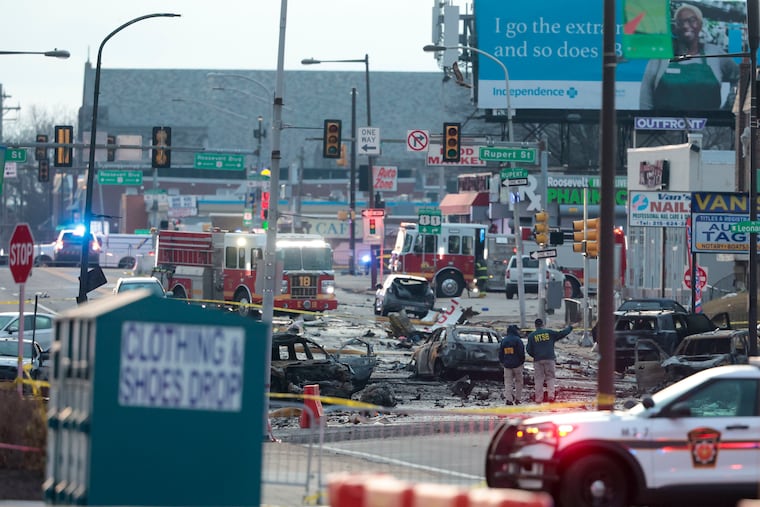 Investigators look at the scene of a plane crash on Cottman Avenue Saturday, Feb. 1, 2025, in Philadelphia. A medical jet with six people on board crashed Friday evening near the Roosevelt Mall in Northeast Philadelphia scattering debris throughout the streets, and setting multiple homes and cars ablaze in a devastating scene