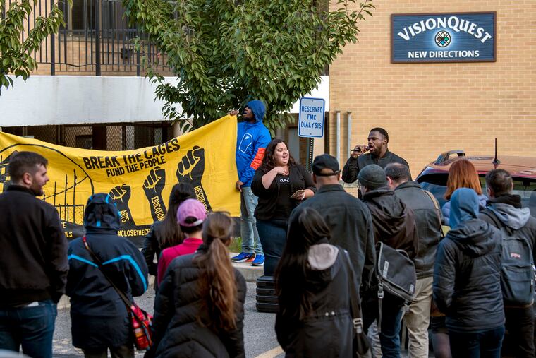 Protesters and Logan neighborhood residents opposed to plans by Arizona-based VisionQuest to house 60 undocumented immigrant children gather outside the company's property on Wednesday. Speaking in front of the group are Erika Almiron, executive director of Juntos, and Josh Glenn, co-founder of the Youth Art & Self-Empowerment Project.