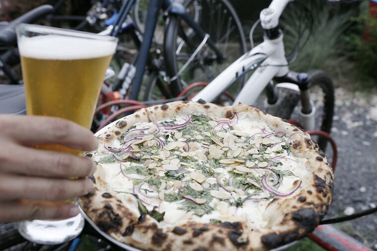 A Stone Go To IPA beer and a Bianco Verde pizza (white pizza, goat cheese, red onion, pesto and garlic almonds) at In Riva.