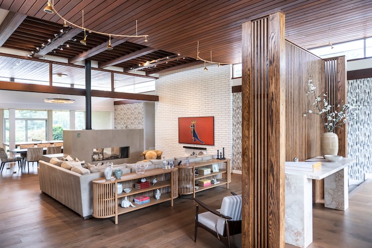 This mid-century modern Cherry Hill has a double-sided fireplace between the main living space and the dining area.