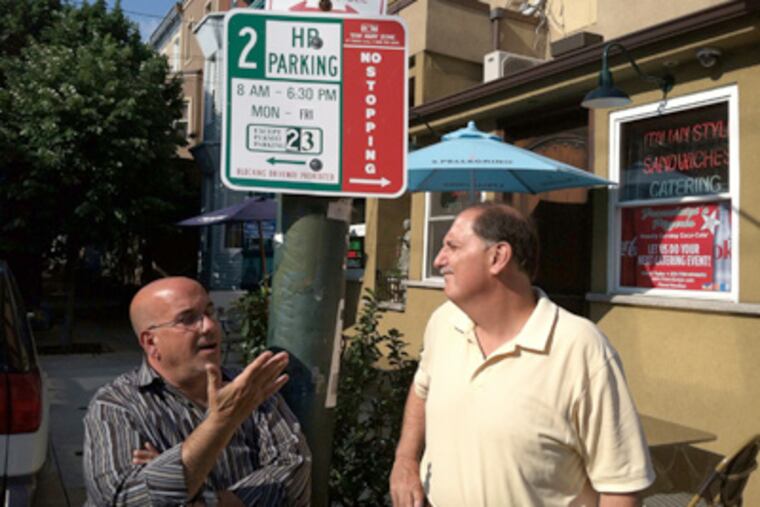 Franco Borda (left) and Michael Giordano, outside Franco & Luigi's restaurant, discuss the problems permit parking has caused their businesses. (Stu Bykofsky / Daily News Staff)