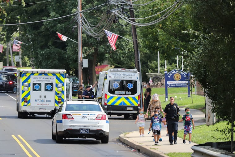 Kids are escorted by police away from the scene of what authorities described as a standoff with a man inside an apartment in the area of the Yardley Commons Condominium Complex on Wednesday. The Yardley police chief was shot in a standoff that ended hours later.