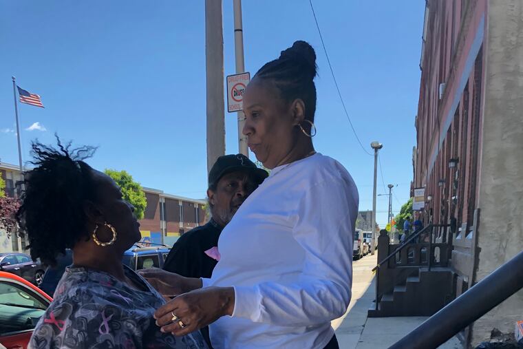 Sonjah Thrower, 54, in white shirt, the mother of gunshot victim Sharita Hardy, 35, greets neighbors on her front steps on Diamond Street on Friday, May 24, 2019. Hardy was shot and injured at the end of the block, at 16th and Diamond Streets, the previous night.