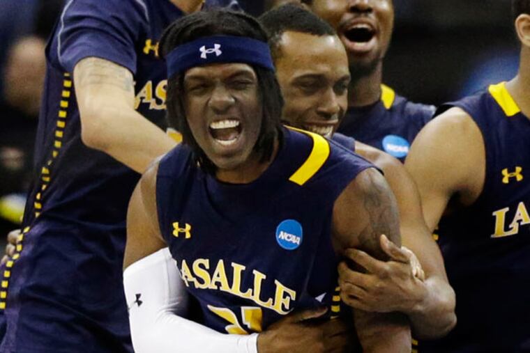 La Salle guard Tyrone Garland (21) celebrates with teammates including
Tyreek Duren (3) after hitting a layup with 2 seconds left to win a
third-round game in the NCAA college basketball tournament against
Mississippi 76-74 at the Sprint Center in Kansas City, Mo., Sunday,
March 24, 2013. (Orlin Wagner/AP)