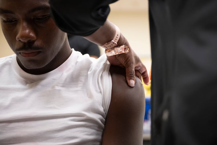 Raphael Preston, 18, a Philadelphia public school student, receives a vaccination on Thursday, August 27, 2026 at Benjamin Franklin High School in Philadelphia.