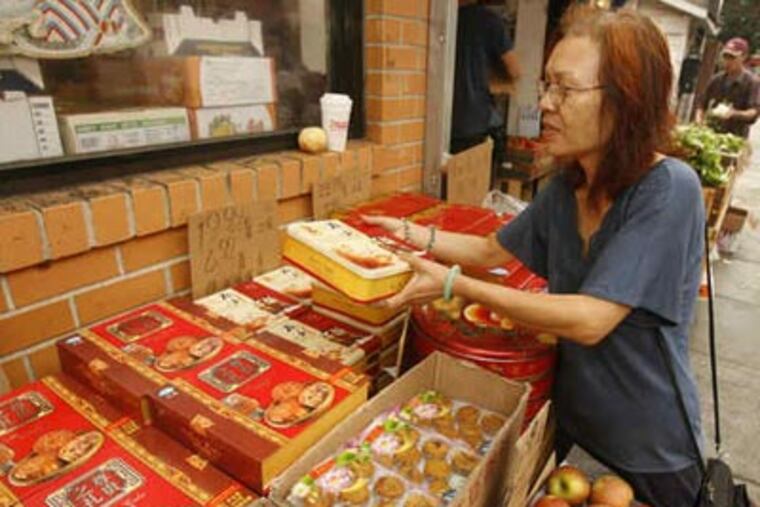 The quest for mooncakes takes Betty Lui to a shop on North 10th Street. Her purchases will be used in the mooncake-eating contest during the Mid-Autumn Festival tomorrow in Chinatown. (Charles Fox / Staff Photographer)