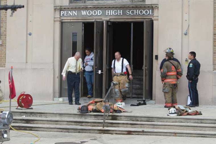 An overnight fire at Lansdowne's Penn Wood High School forced officials to cancel classes Thursday. Here,officials and fire personnel exit the school after evaluating damage ( ED HILLE / Staff Photographer )