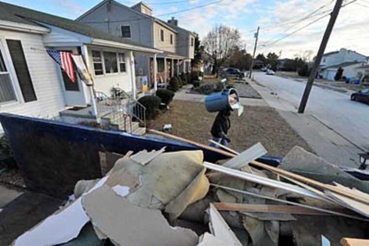 The ruins of 5 Cummings Place in Brigantine are prepared for removal by construction worker Louis Doto, who came east from Crane, Mo., to help rebuild properties at the Shore. CLEM MURRAY / Staff Photographer