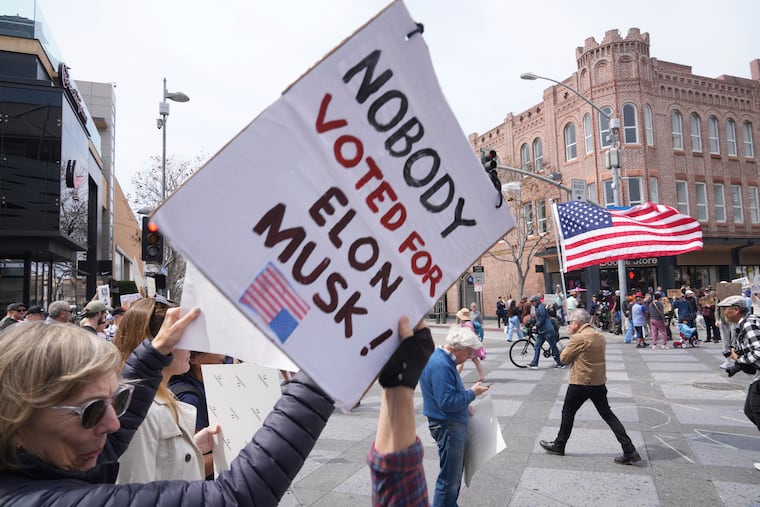 Protesters hold a demonstration outside a Tesla showroom in Santa Monica, Calif., on Saturday, against President Donald Trump and Tesla CEO Elon Musk.