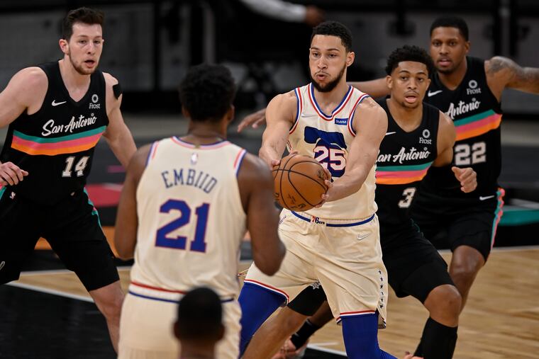 The Sixers' Ben Simmons (25), who scored the winning basket, passes to teammate Joel Embiid (21), who had 34 points and 12 rebounds. San Antonio's Keldon Johnson (3), Drew Eubanks (14), and Rudy Gay defend on the play.