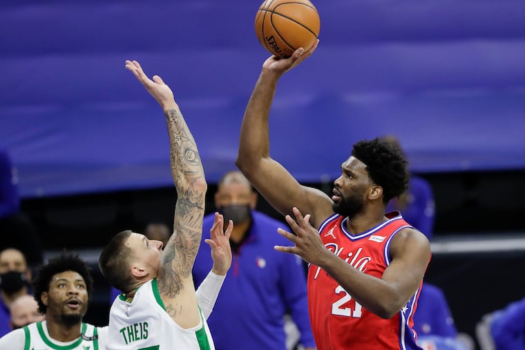 Sixers center Joel Embiid shoots over Boston Celtics center Daniel Theis.