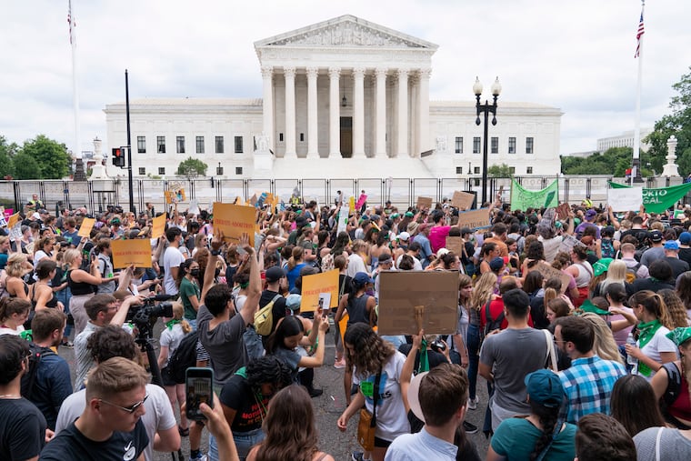 Protesters gather outside the U.S. Supreme Court Building in Washington in June 2022, following the justices' decision to overturn "Roe v. Wade." Overturning "Roe v. Wade" and affirmative action in higher education had been leading goals of the conservative legal movement for decades. Over a span of 370 days, a Supreme Court reshaped by three justices nominated by President Donald Trump made both of those objectives a reality.