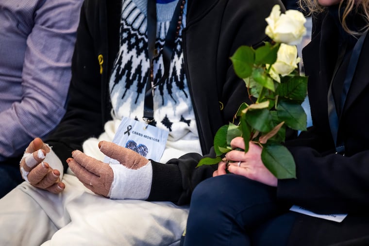 A victim with burned hands and relatives attend the official commemorative ceremony for the victims of the deadly fire at the "Le Constellation" bar in Crans-Montana, in Martigny, Switzerland, Friday, Jan. 9, 2026. (Laurent Gillieron/Keystone/Pool via AP)