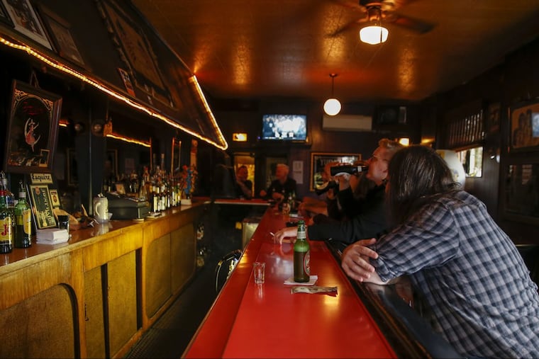 Customers sit at the bar inside the Friendly Lounge.