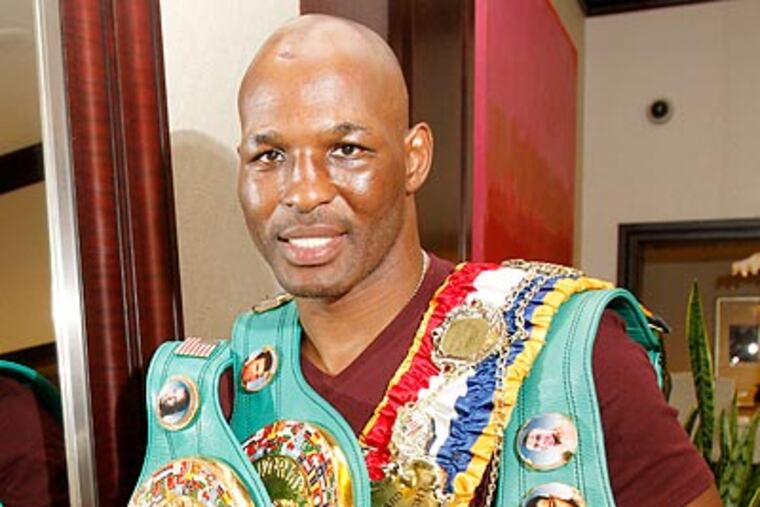 Bernard Hopkins holds his title belts after winning the WBC light heavyweight belt. (Charles Fox/Staff Photographer)