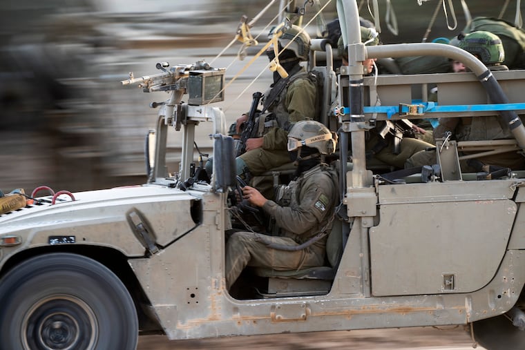 Israeli army soldiers drive into an army staging area near the Gaza Strip border on Sunday.