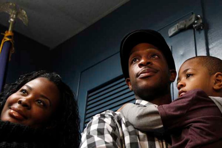 Nelson Mandela Myers, center, holds his child, Gary, right, as his wife, Janie, left, pauses to talk with reporters at Upper Darby Police Dept. in Upper Darby, Pa., on January 15, 2013. Nelson Mandela Myers, who is being called a hero, found Nailla Robinson, 5, who went missing after she was abducted from her school. She was found early in the morning as Myers was going to work. ( DAVID MAIALETTI / Staff Photographer )