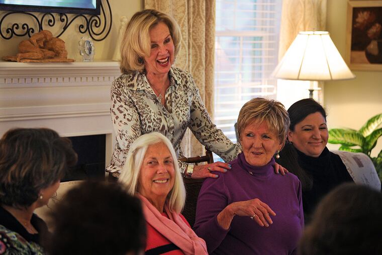 Host Mary Jane Hurley Brant, standing, makes sure all the participants are comfortable before the monthly meeting of Mothers Finding Meaning Again.