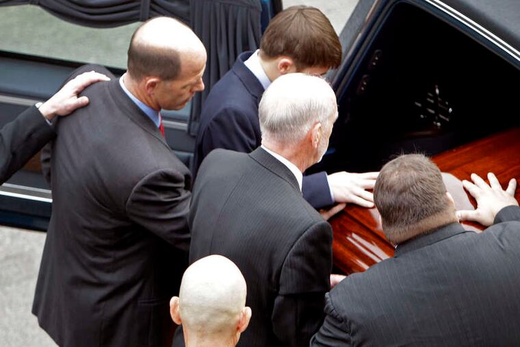 Pallbearers, including Joe Paterno's son, Scott (bottom right), place casket into the hearse before the funeral procession around the Penn State campus.
