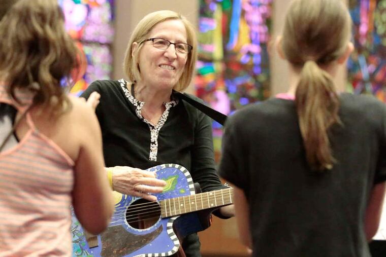 Students clap as music teacher Liz Sussman plays guitar after celebrating Simchat Torah. (ELIZABETH ROBERTSON / Staff Photographer)