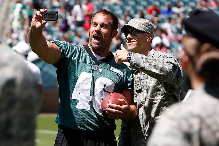 Jon Dorenbos, left, takes a photo with Mike Downs, a Special Forces candidate, before the start of Eagles training camp at Lincoln Financial Field on Aug. 5, 2013.