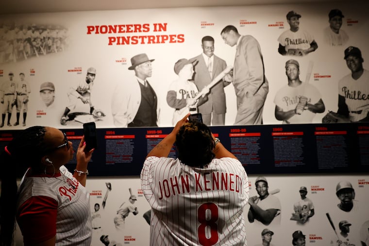 Family members of Phillies pioneer John Kennedy take photos of the new ‘Pioneers in Pinstripes’ display to families of the club’s first black and minority players on Jackie Robinson Day at the Hall of Fame Club at Citizens Bank Park.