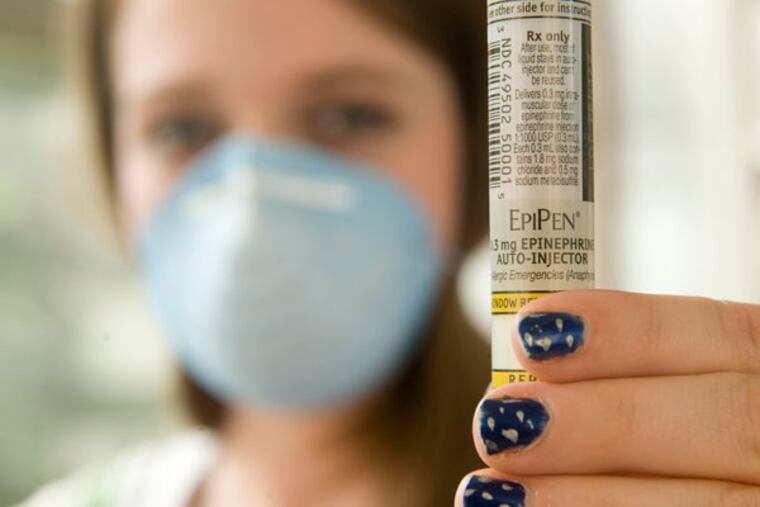 Danielle Davis,a Capital High school student with severe nut allergies, displays an EpiPen and wears a protective mask during an interview in Charleston, W.Va., in this April 2008 file photo. (AP File Photo/Bob Bird)