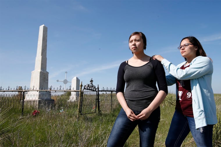 Asia Gilbertson Black Bull, left, and Shylee Brave of the Sicangu Youth Council, stand by the the grave of Chief Spotted Tail on May 12, 2016. Spotted Tail was among the first chiefs to agree to send children to Carlisle.