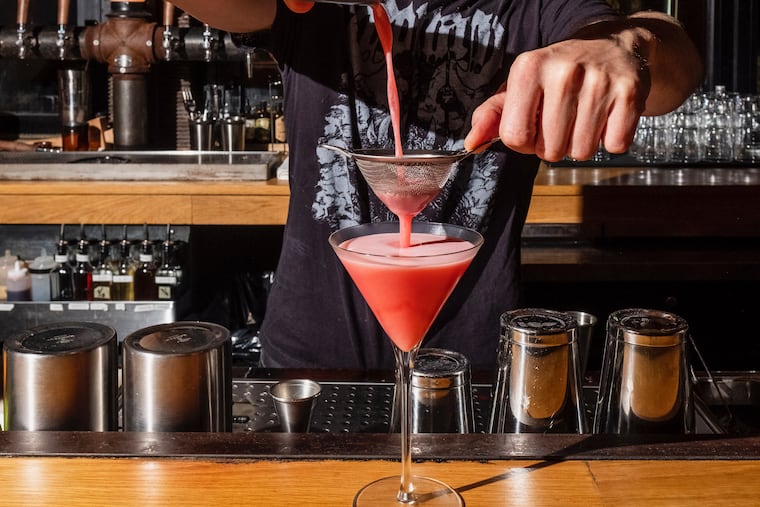 Next of Kin co-owner John Grubb pours a Clover Club cocktail.