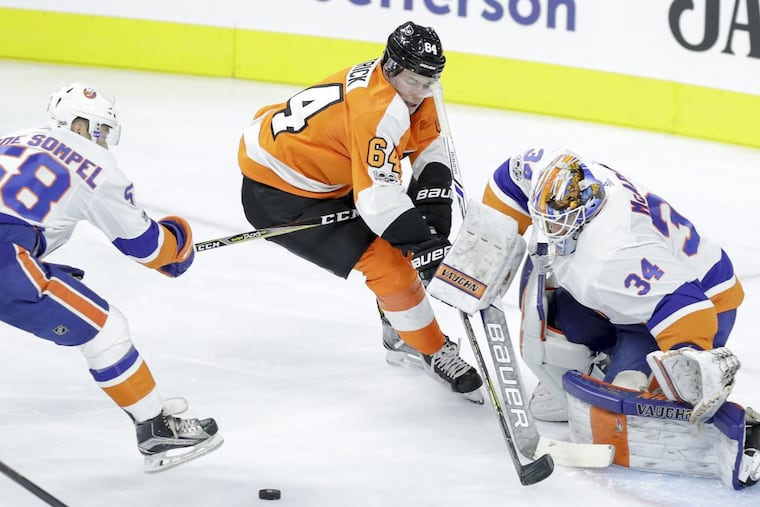 Flyers Nolan Patrick goes after the puck against New York Islanders goalie Eamon McAdam and Mitchell Vande Sompel during the teams rookie game on Wednesday.