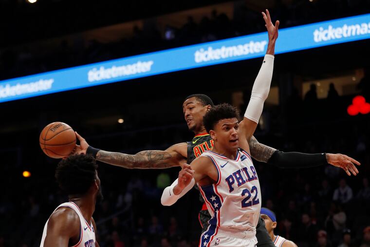 Atlanta Hawks forward John Collins (rear) passes around 76ers guard Matisse Thybulle (22) during the first half of Thursday's game.