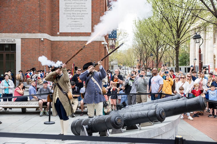 Matthew Skic, of Morristown, N.J., director of Collections and Exhibitions (left), and Michael Hensinger, of Fishtown, senior manager of K-12 Education (right), are dressed as Minute Men from the Massachusetts Militia for the opening of the new exhibit, Banners of Liberty, which showcases original Revolutionary War flags at the Museum of the American Revolution in Philadelphia. They fired shots to celebrate the 250th anniversary of the "shot heard 'round the world," which started the American Revolutionary War.