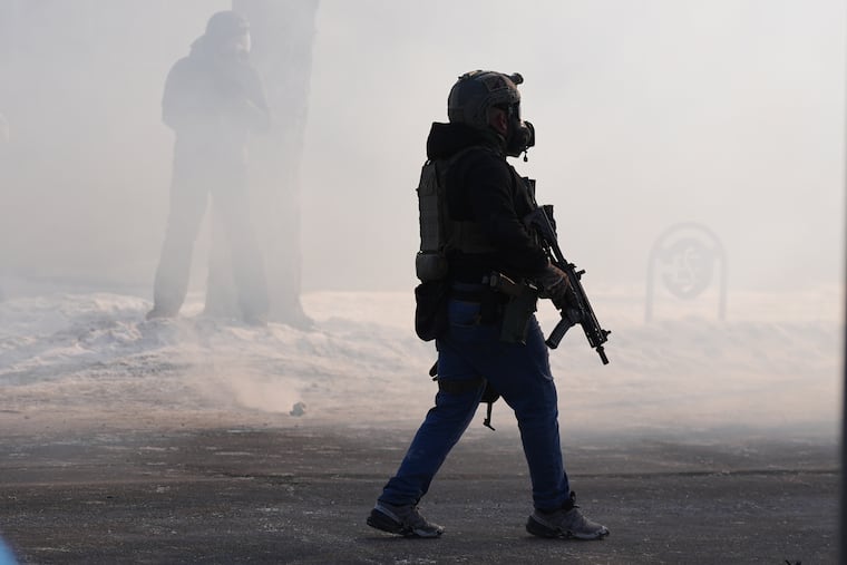 Armed federal immigration officers deploy tear gas after a shooting Saturday, Jan. 24, 2026, in Minneapolis.