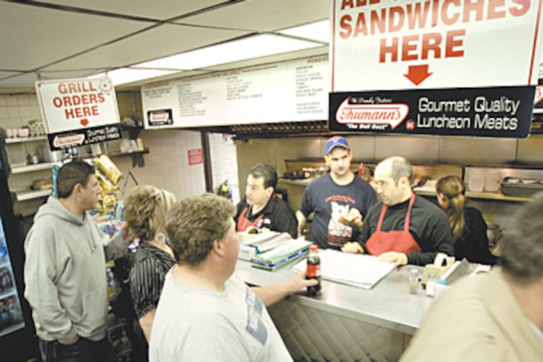 Customers line up to place their orders at John's Roast Pork at 14 E. Snyder Ave in Philadelphia. John Bucci Jr. (dark hair) takes an order. (Laurence Kesterson / Inquirer)