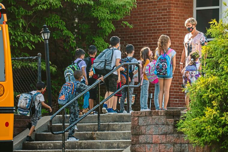 Students arrive masked to Memorial Elementary School in Bethel Park, Pa., a Pittsburgh suburb, in August. In a heated school board meeting the previous evening, the Bethel Park School District voted to amend the district's health and safety plan and require all students, staff and visitors to wear masks inside the district's schools.