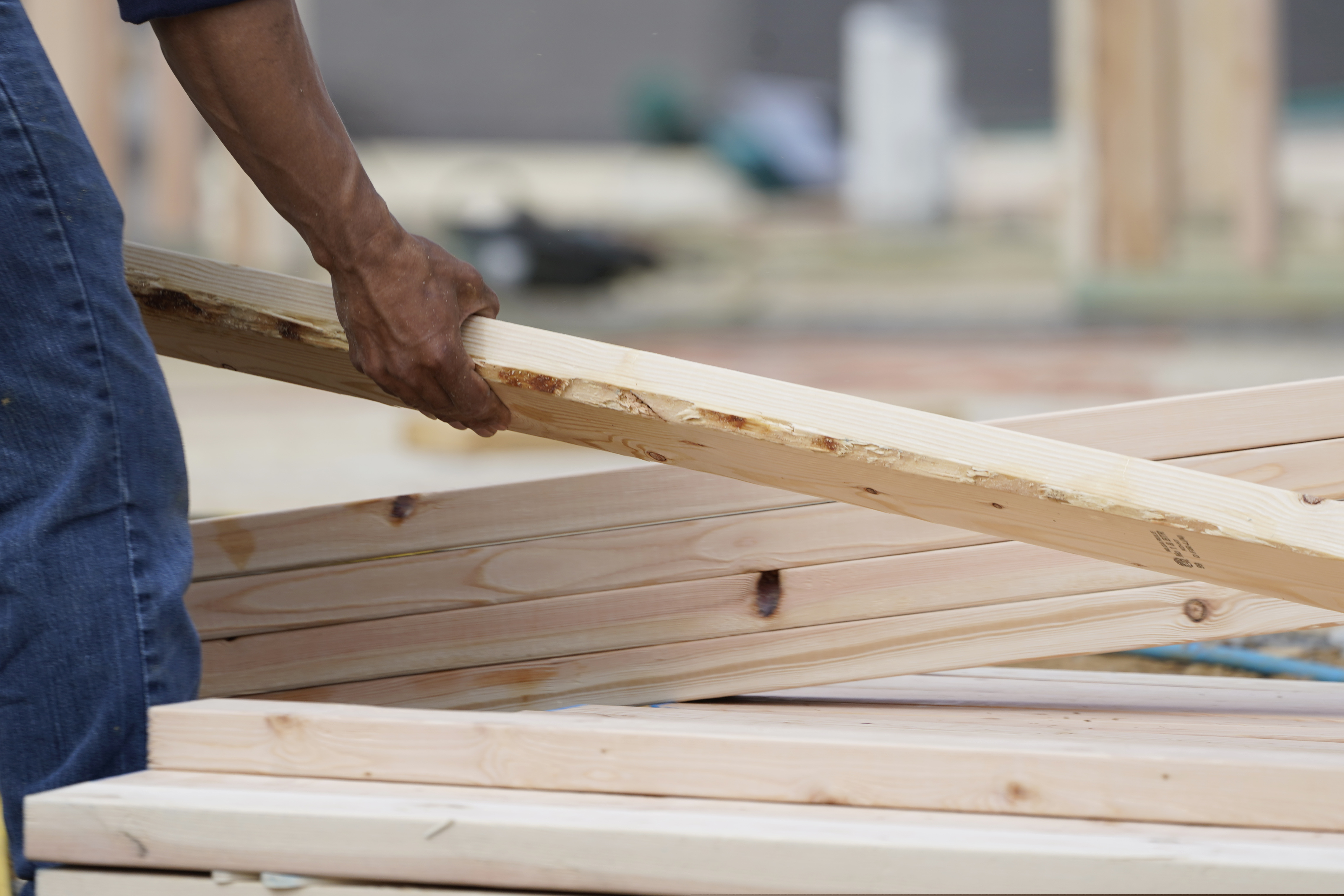A workman arranges a beam on a frame at a new housing site in Madison County, Miss., in March.