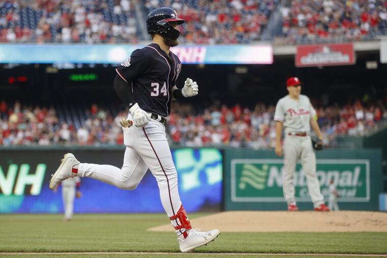 Nationals star Bryce Harper rounds the bases after a leadoff home run against Nick Pivetta (right) in the Phillies’ 7-3 loss on Friday.